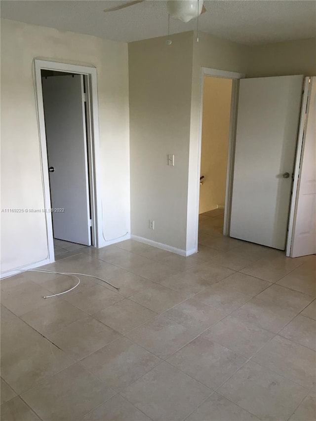 unfurnished room featuring ceiling fan and a textured ceiling