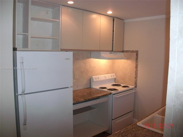 kitchen with decorative backsplash, white cabinets, dark stone counters, and white appliances