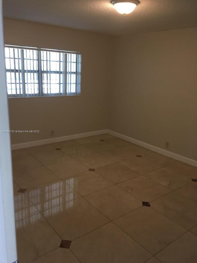 empty room featuring tile patterned floors and a textured ceiling