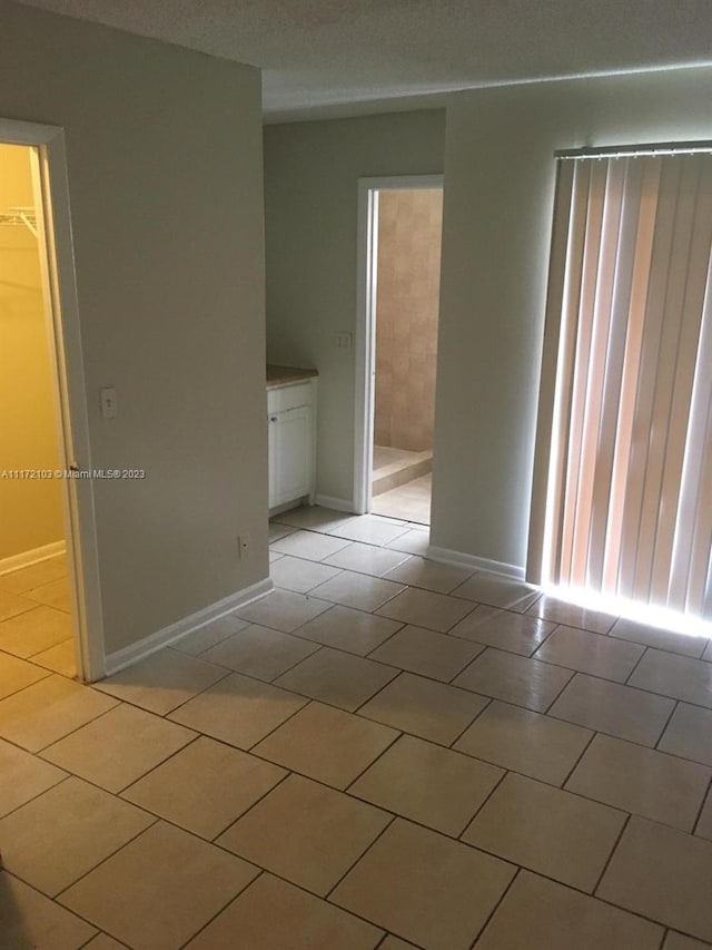 empty room featuring light tile patterned floors and a textured ceiling