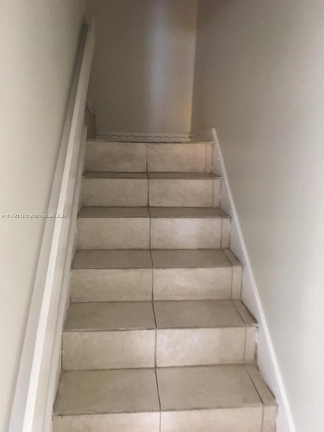 staircase featuring tile patterned flooring