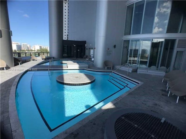 view of pool with a jacuzzi and a patio area