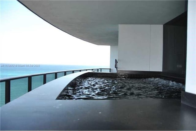 exterior space featuring a balcony and a water view