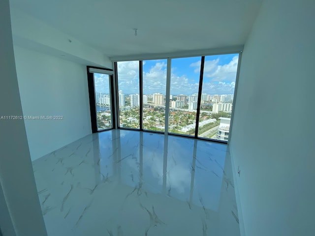 tiled spare room with floor to ceiling windows and a wealth of natural light