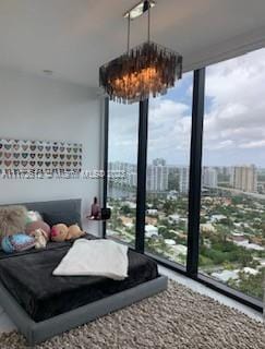 bedroom featuring an inviting chandelier, expansive windows, and multiple windows