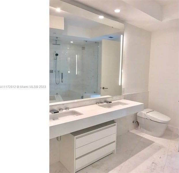 bathroom with tile flooring, large vanity, and toilet