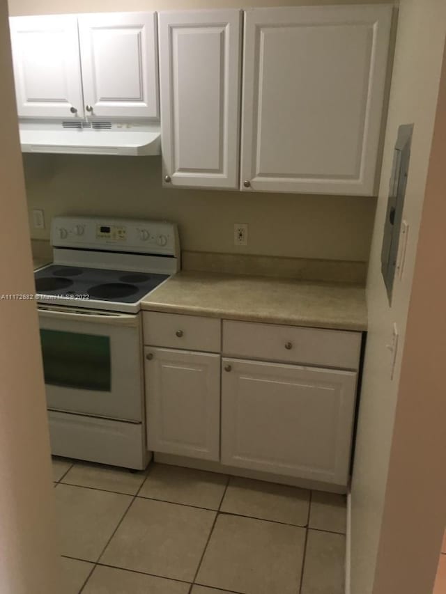 kitchen featuring white cabinetry, white electric range, and light tile patterned floors