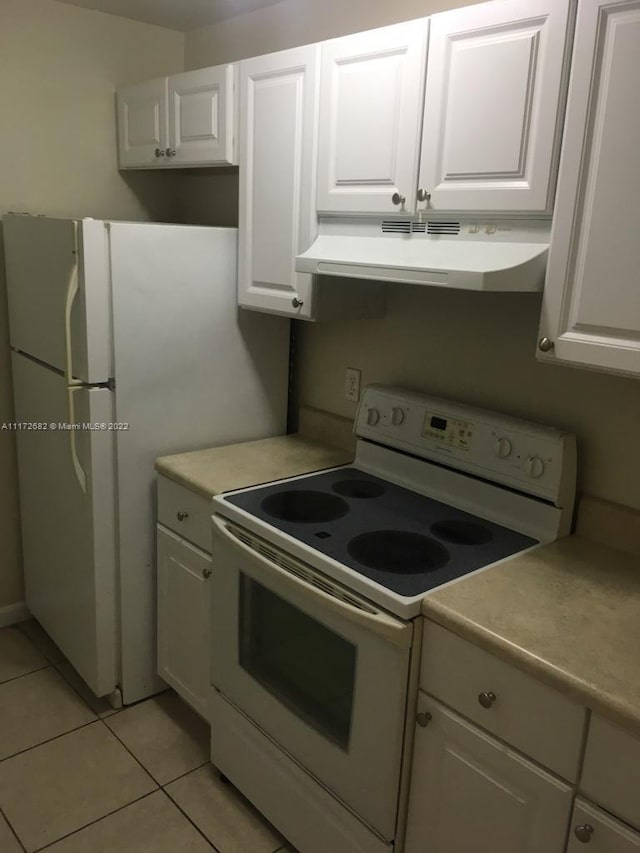 kitchen with white cabinets, white electric stove, and light tile patterned flooring