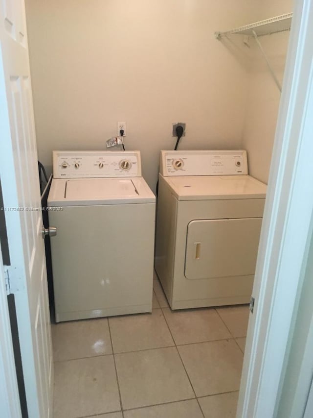 washroom featuring washing machine and clothes dryer and light tile patterned flooring