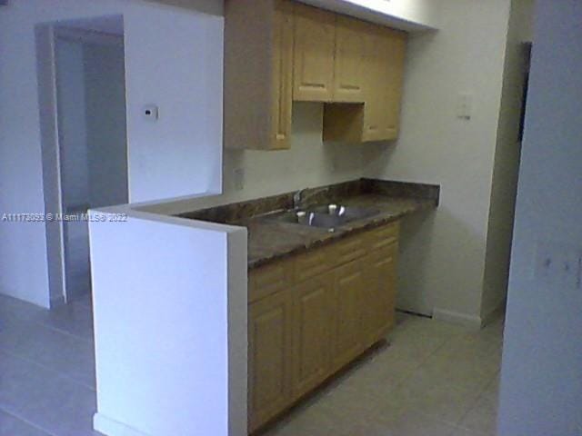 kitchen featuring sink and light tile patterned flooring