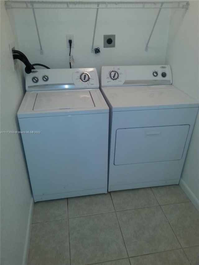 laundry room featuring light tile patterned flooring and separate washer and dryer