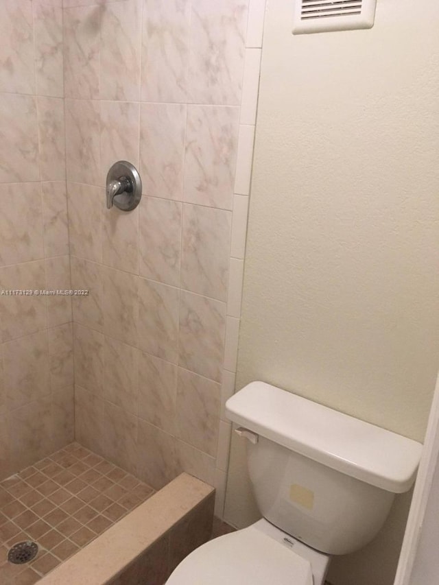 bathroom featuring toilet and tiled shower