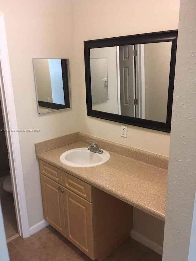 bathroom featuring tile patterned flooring, vanity, and toilet