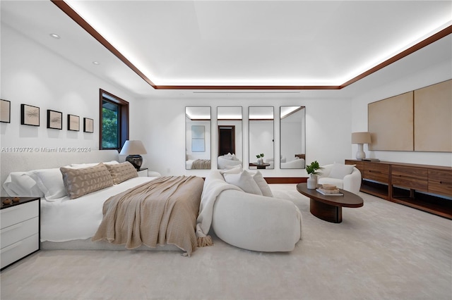 bedroom with carpet floors and a raised ceiling