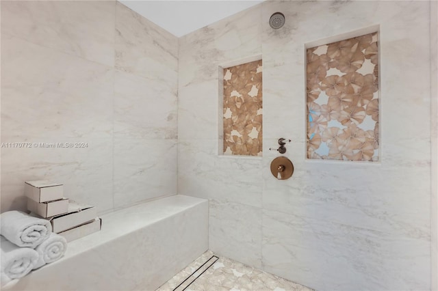 bathroom with a tile shower and tile walls