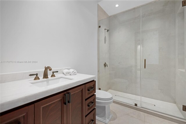 bathroom with vanity, tile patterned flooring, toilet, and an enclosed shower