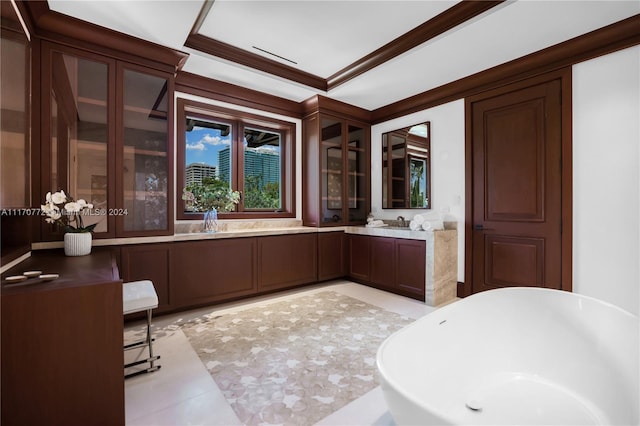 bathroom with tile patterned floors, crown molding, vanity, and a bathtub