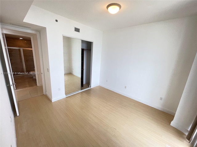 unfurnished bedroom with a closet and light hardwood / wood-style flooring