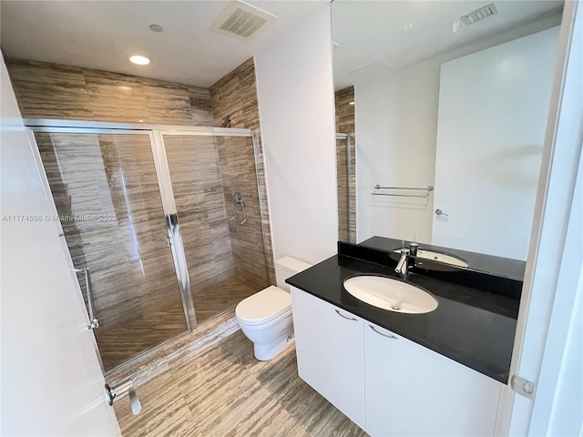 bathroom featuring toilet, an enclosed shower, and vanity