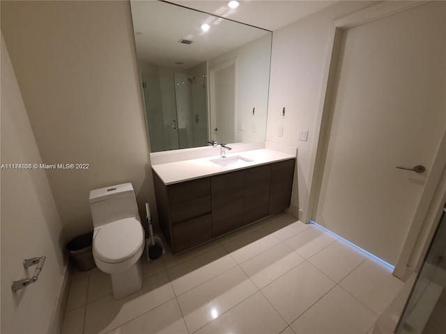 bathroom with toilet, large vanity, and tile floors