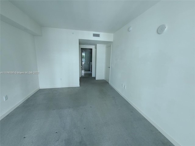 unfurnished room with dark colored carpet