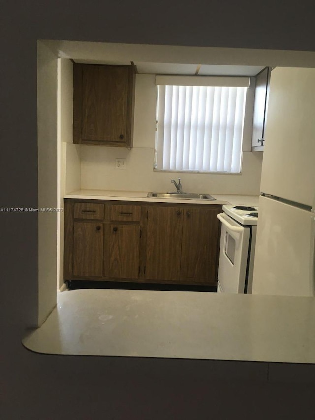 kitchen featuring white appliances and sink