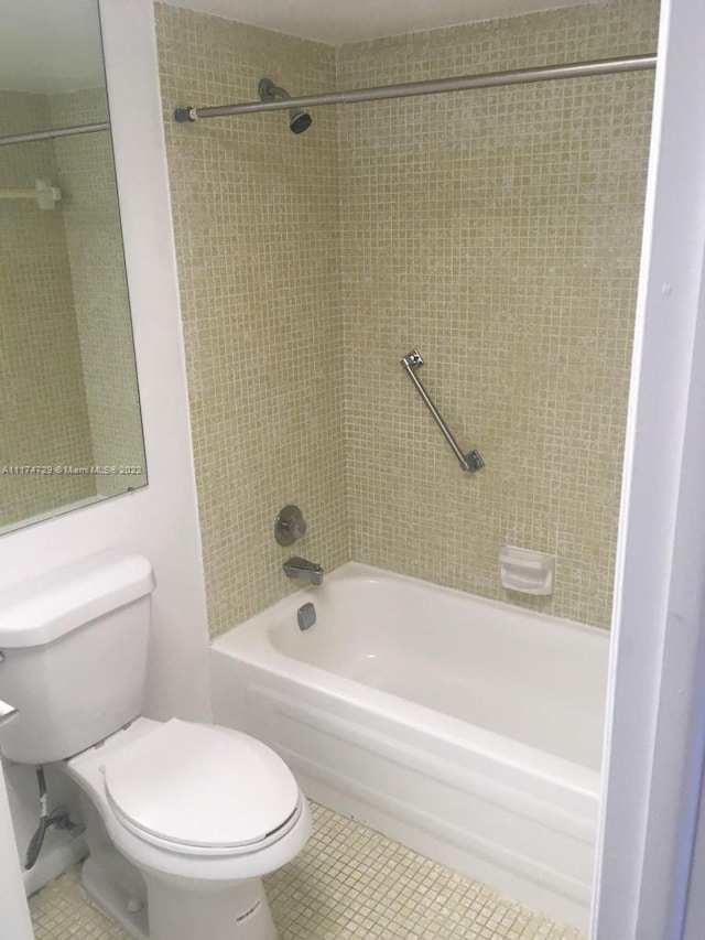 bathroom featuring tile patterned floors, tiled shower / bath combo, and toilet