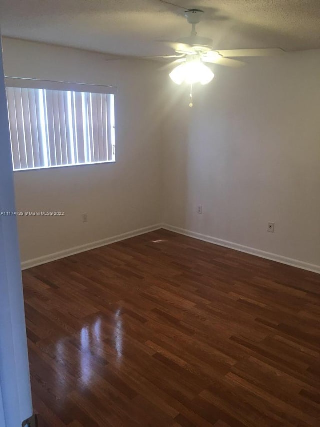 unfurnished room featuring dark hardwood / wood-style flooring and ceiling fan