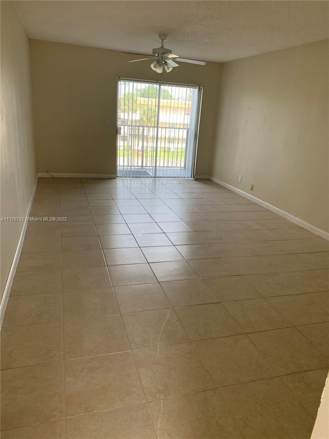 tiled spare room with ceiling fan and a textured ceiling