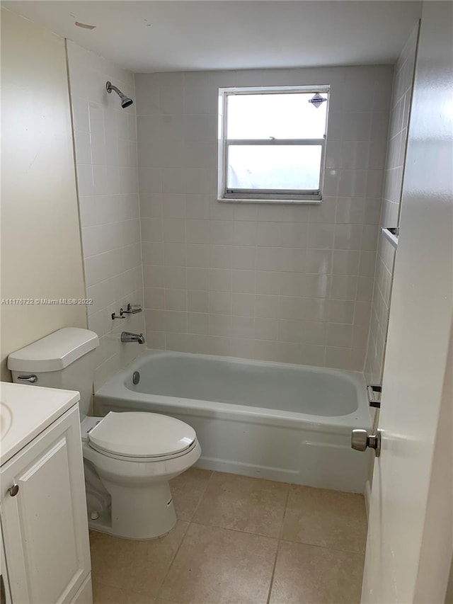 full bathroom with tile patterned flooring, vanity, tiled shower / bath combo, and toilet