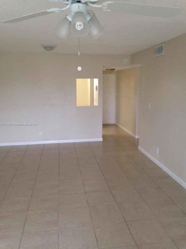 unfurnished room with light tile patterned floors, a textured ceiling, and ceiling fan