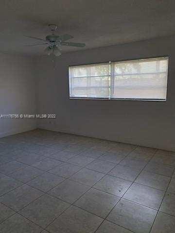 tiled spare room featuring ceiling fan