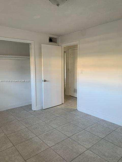 unfurnished bedroom featuring a closet and light tile patterned flooring