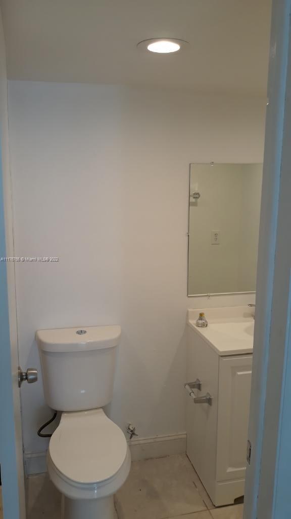 bathroom featuring tile patterned floors, vanity, and toilet