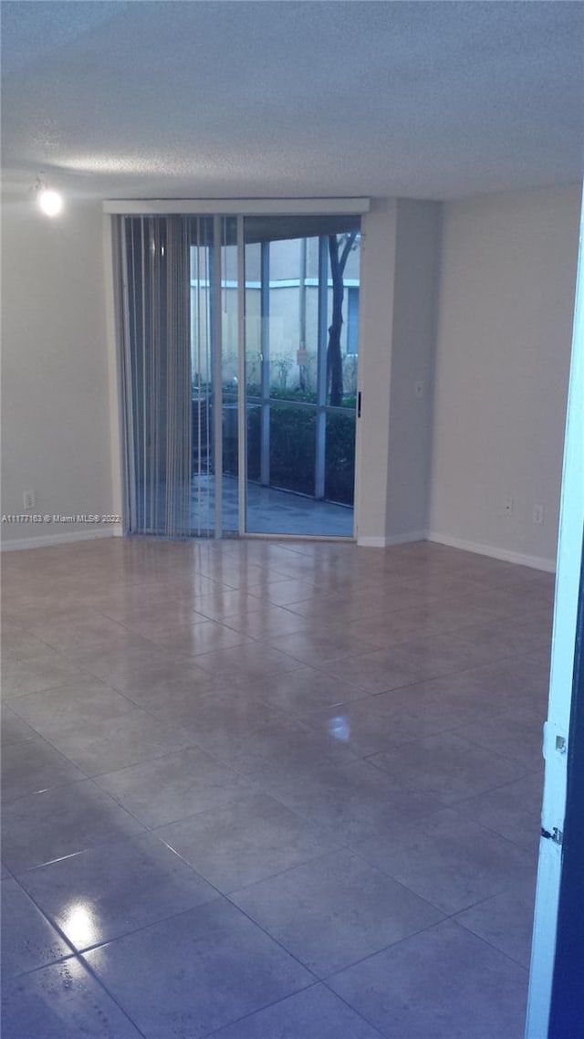 spare room featuring floor to ceiling windows and a textured ceiling