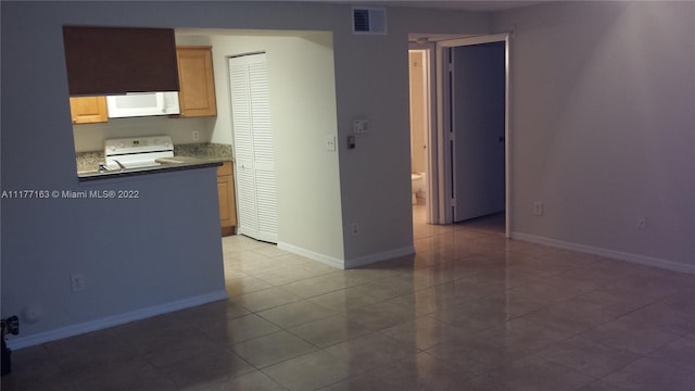 kitchen with tile patterned floors and white appliances