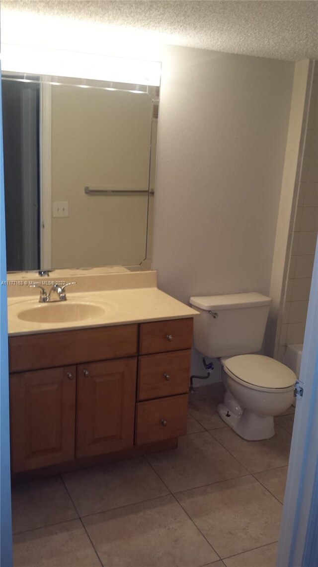 bathroom with vanity, tile patterned floors, a textured ceiling, and toilet