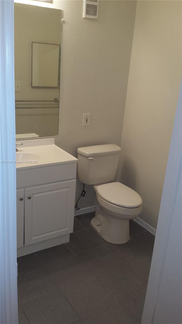 bathroom featuring tile patterned flooring, vanity, and toilet