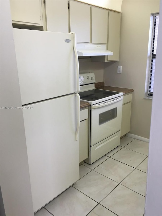 kitchen with light tile patterned floors and white appliances