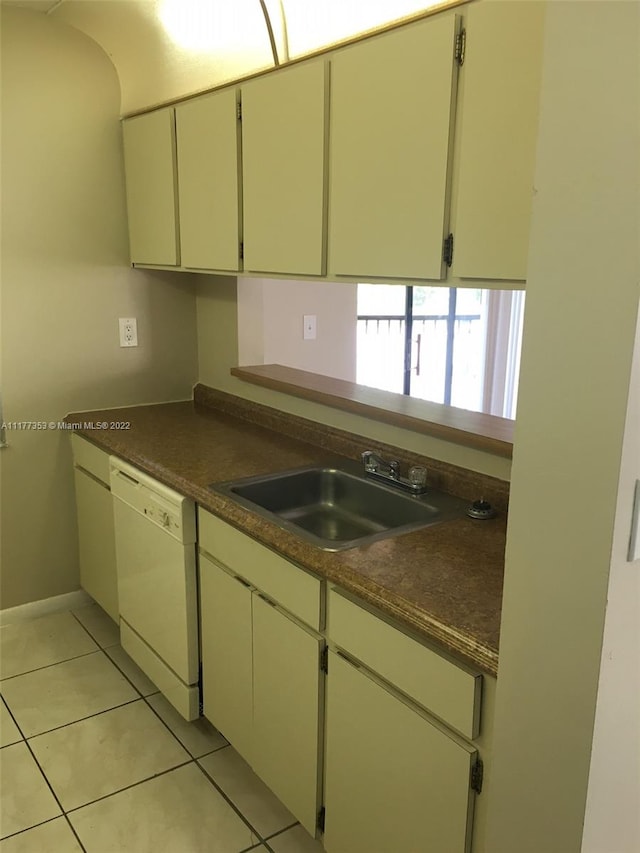 kitchen featuring dishwasher, cream cabinetry, sink, and light tile patterned flooring