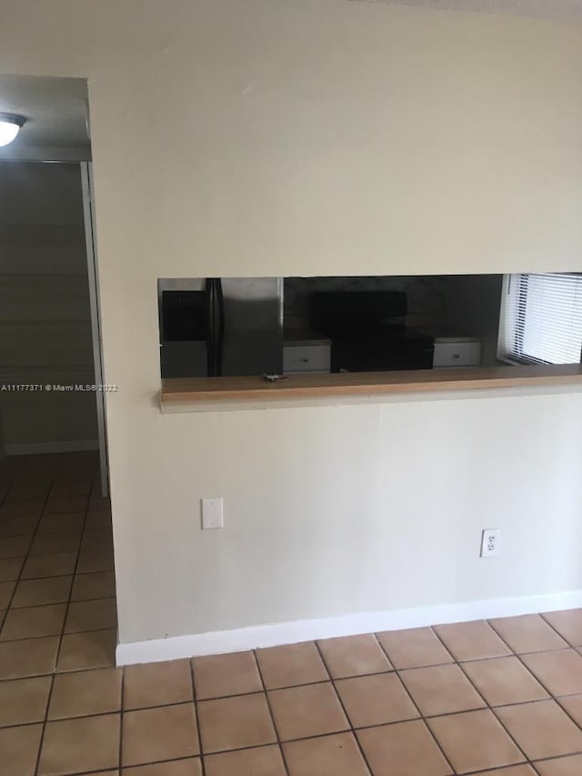 kitchen featuring tile patterned flooring and black fridge