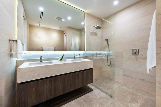 bathroom featuring dual vanity and a shower with shower door