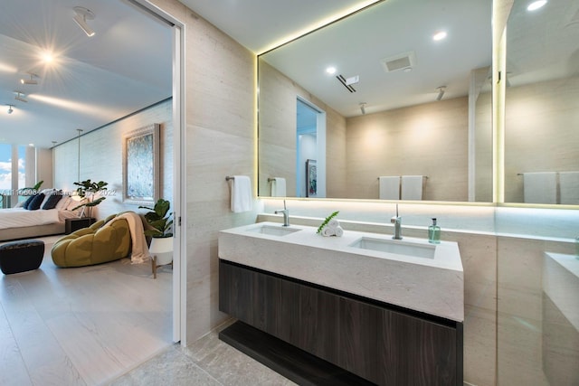 bathroom with tile walls and double sink vanity