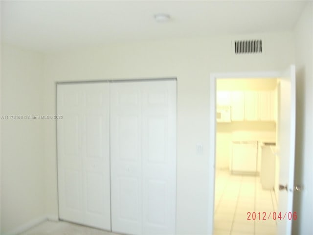 unfurnished bedroom with light tile patterned floors and a closet