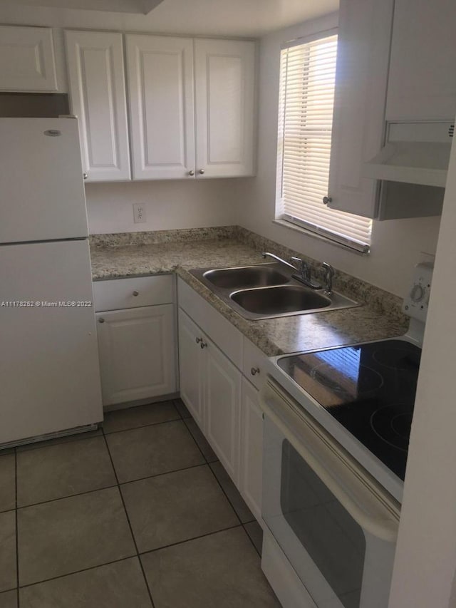 kitchen featuring white cabinets, white appliances, tile patterned flooring, and sink