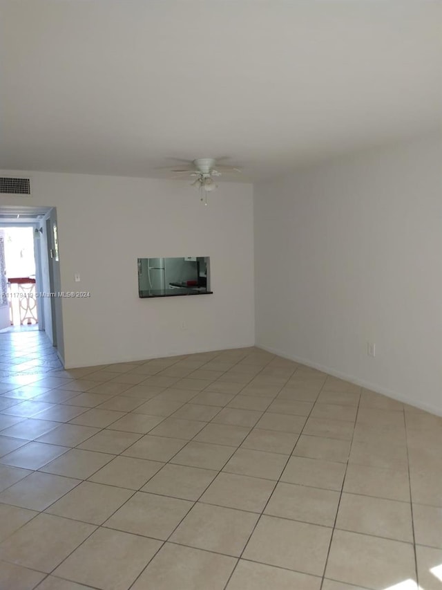 tiled empty room with ceiling fan