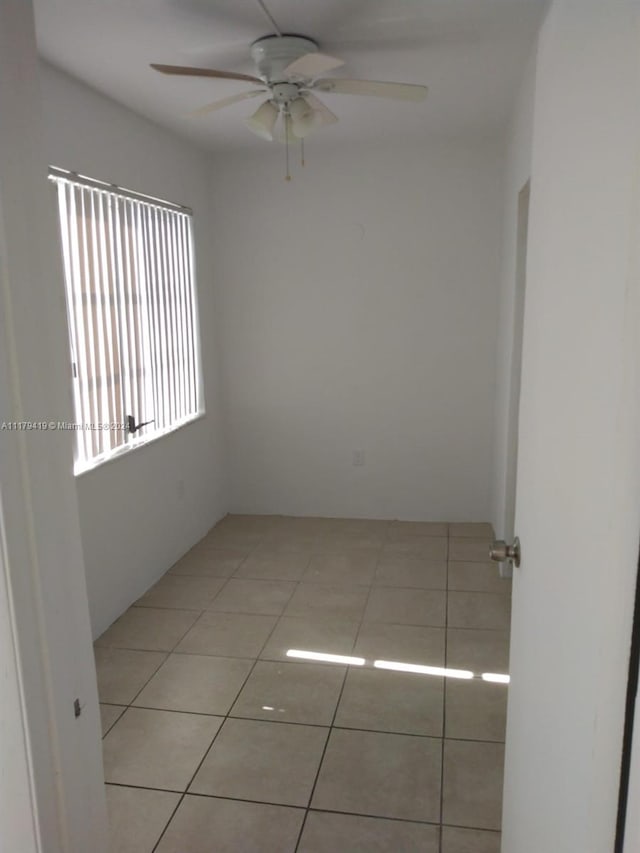 tiled empty room with ceiling fan