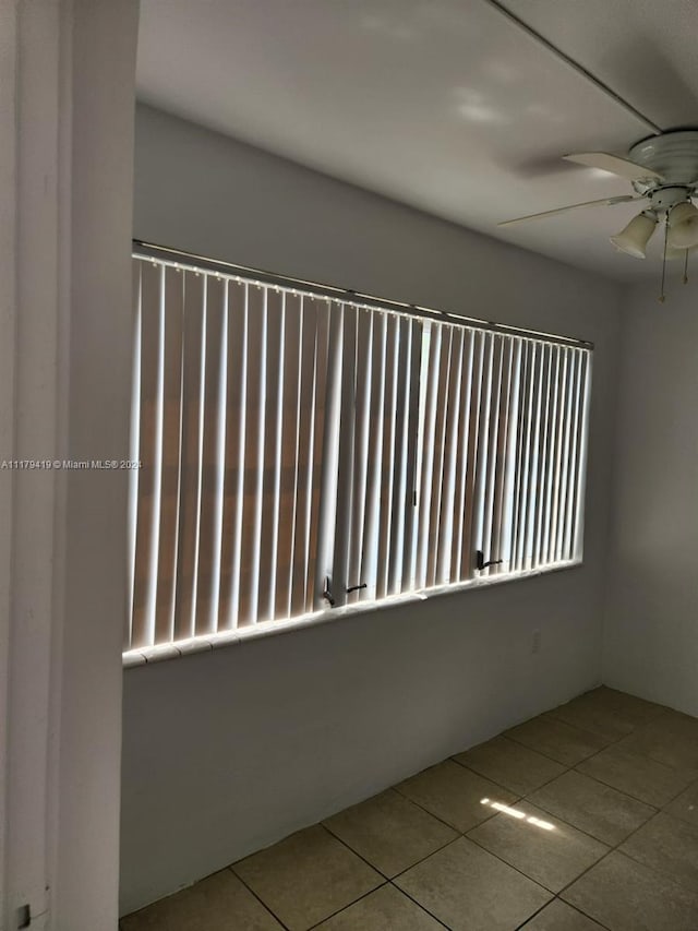 tiled spare room featuring ceiling fan