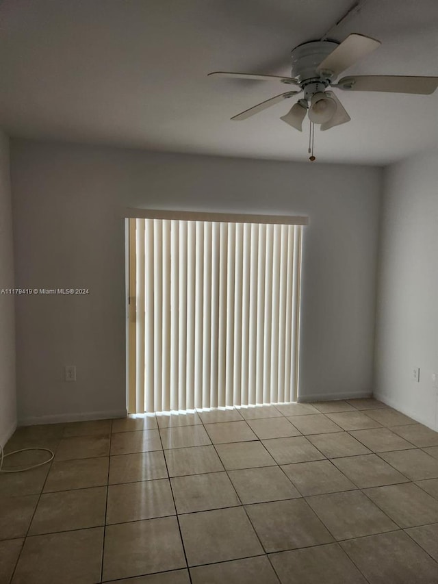 tiled empty room with ceiling fan