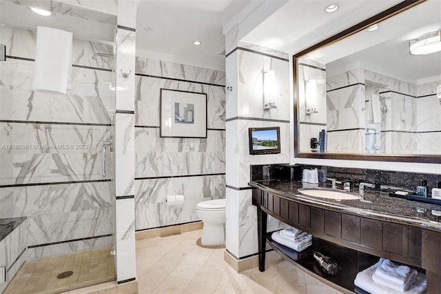 bathroom featuring toilet, a shower with door, vanity, tile walls, and tile flooring